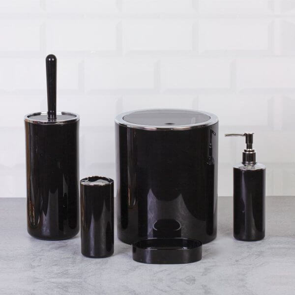 Set accessori da bagno tondo lucido nero con finiture cromate su sfondo grigio chiaro.