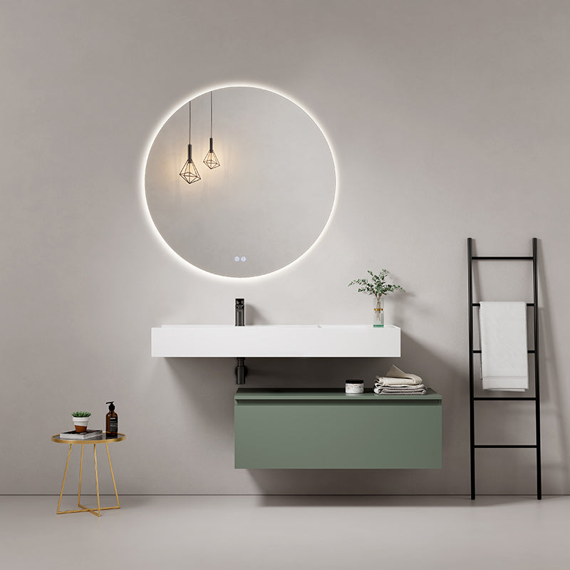 Modern bathroom setup featuring a sleek suspended sink, round illuminated mirror, and green cabinet.