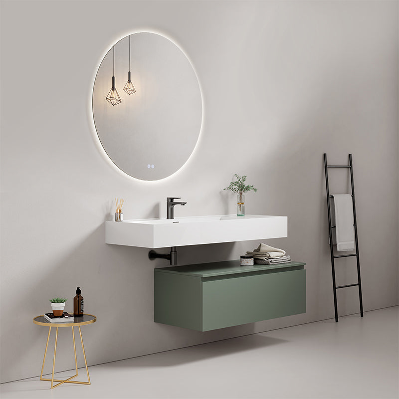 Modern floating bathroom sink with green cabinet, round mirror, and stylish decor in contemporary setting.
