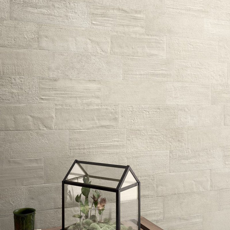 rivestimenti di lusso per la casa, parete in tonalità chiara con vaso decorativo e terrarium.