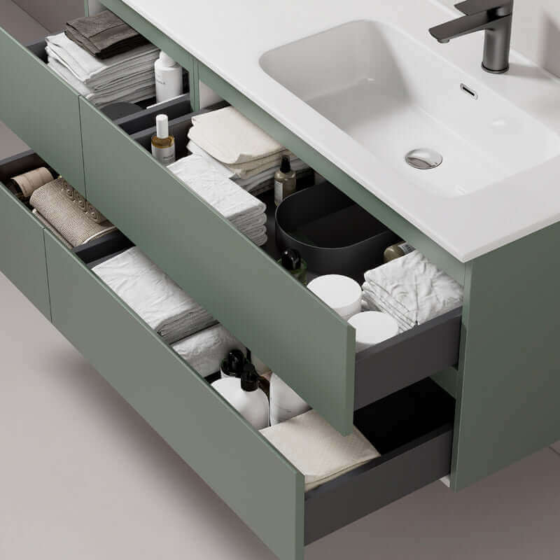 Dettaglio mobile bagno sospeso verde salvia con cassetti aperti e lavabo, organizzazione interna in stile moderno. (25686996)