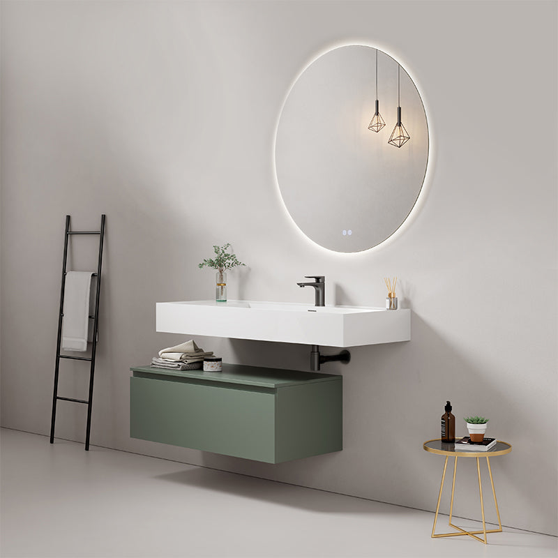 Modern bathroom with wall-mounted sink, green drawer, round mirror, and stylish lighting.