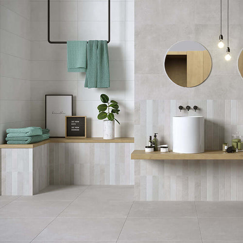 Modern bathroom featuring grey ceramic tiles, wooden accents, and plants, showcasing Rivestimento in Ceramica Decoro 25x60.