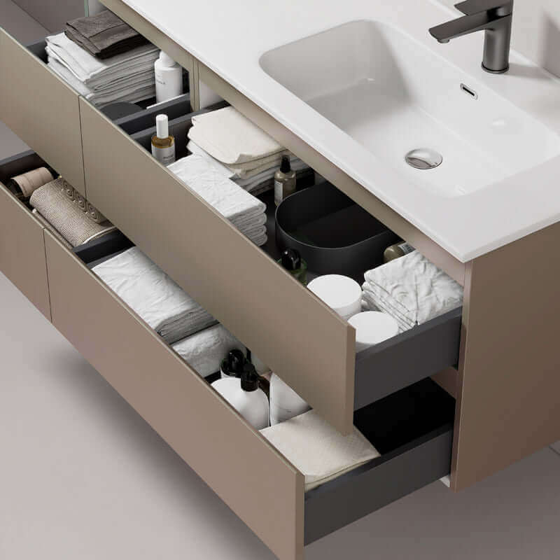 Interni di un mobile bagno sospeso con cassetti aperti, organizzatori di asciugamani e prodotti per la cura personale.