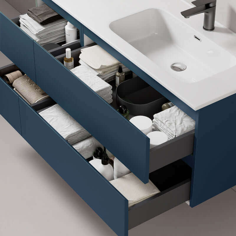 Mobile bagno sospeso Fiji da 140 cm in Blu Mare con cassetti aperti, mostrando contenuti organizzati e lavabo incorporato. (25686260)