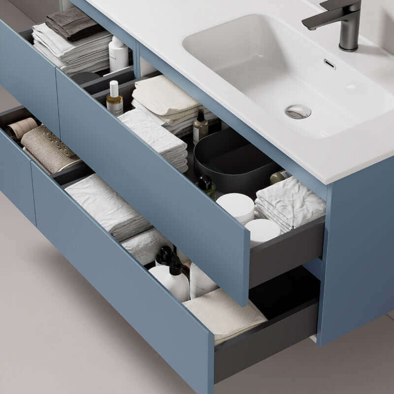 Mobile bagno sospeso blu avio con lavabo, cassetti aperti mostrano asciugamani e prodotti per il bagno (25686141)