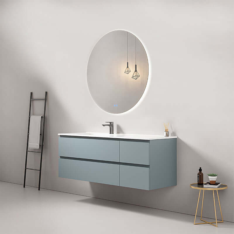 Mobile bagno sospeso blu avio con lavabo a sinistra e specchio rotondo retroilluminato nel design moderno