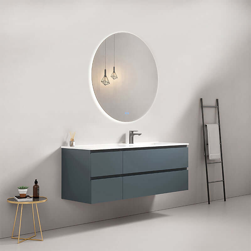 Mobile bagno sospeso blu mare con lavabo a destra e specchio retroilluminato tondo su parete elegante.