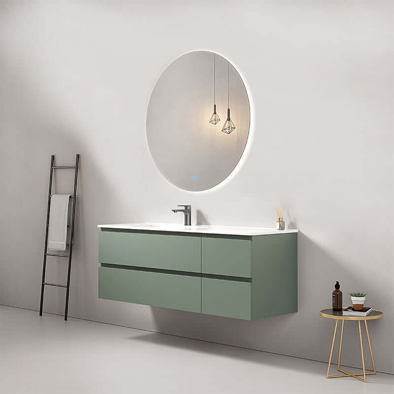 Mobile bagno sospeso verde salvia 140 cm con lavabo a sinistra e specchio tondo retroilluminato.