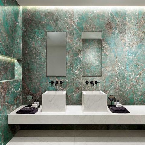 Luxurious bathroom featuring green marble wall tiles, dual sinks, and modern mirrors for an elegant design.