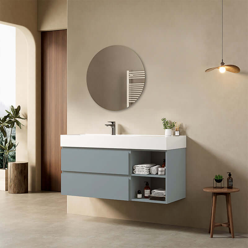 Mobile bagno sospeso blu avio con lavabo, specchio tondo e design contemporaneo in un elegante bagno moderno.