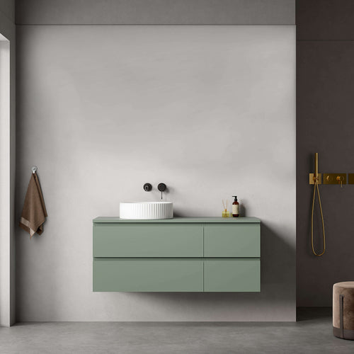 Mobile bagno sospeso verde salvia con lavabo d'appoggio in un ambiente moderno e minimalista.