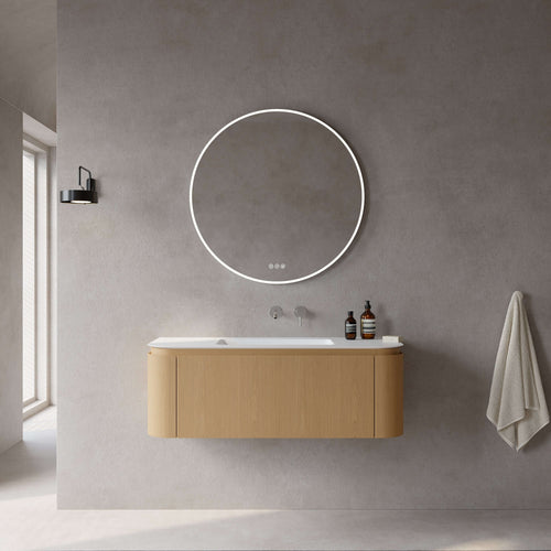 Mobile bagno sospeso in rovere chiaro con specchio tondo retroilluminato in moderno ambiente minimalista.
