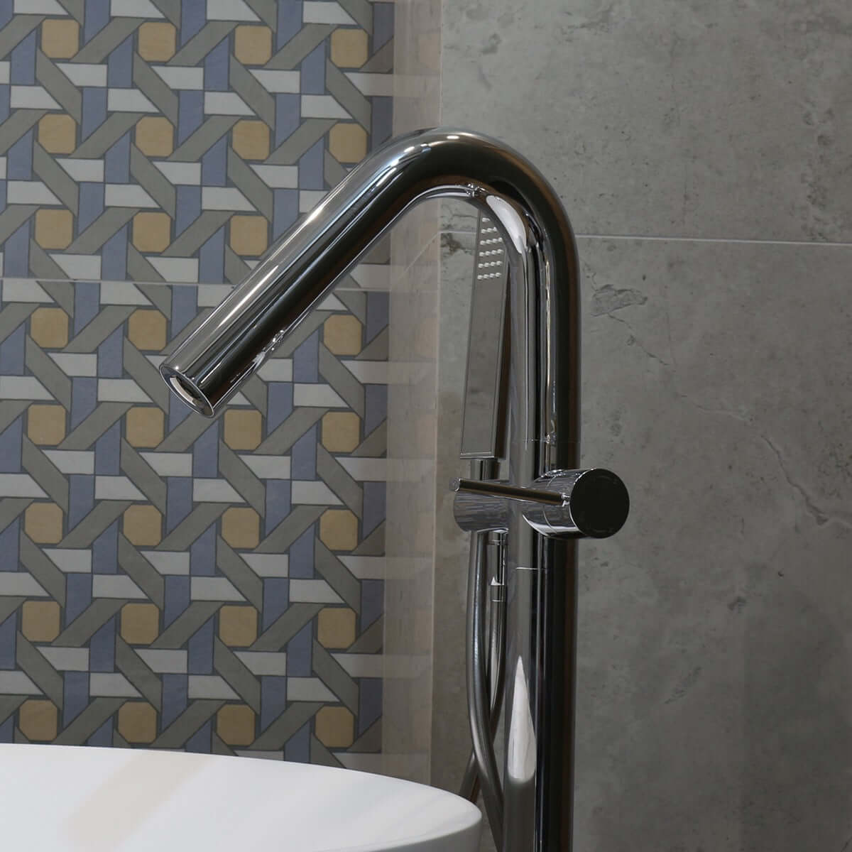 Miscelatore a pavimento per vasca freestanding con doccino cromo Neptune in bagno moderno con piastrelle decorative.